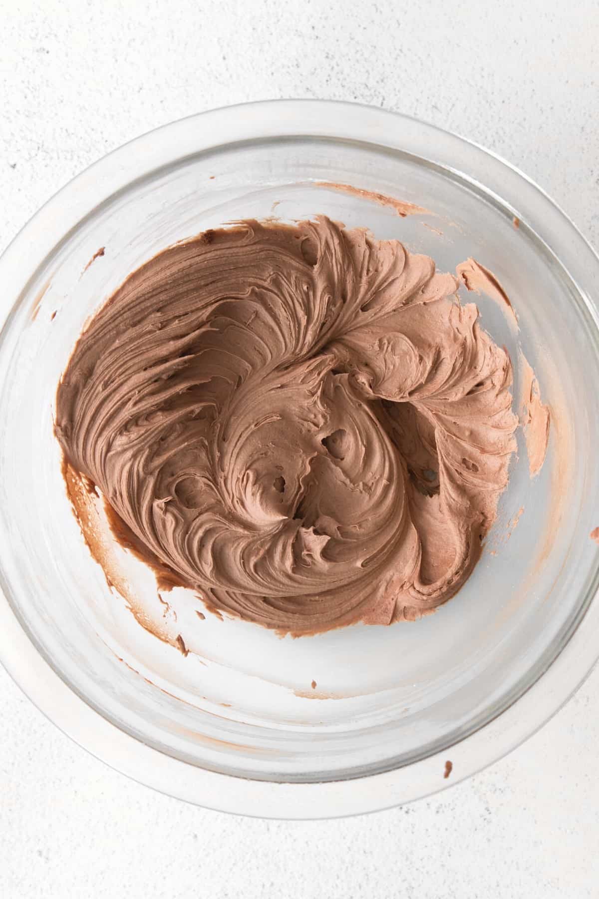 Chocolate buttercream in a glass bowl.