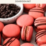 Cherry macarons and chocolate chips on parchment paper.