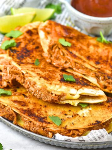 Chicken birria tacos with sauce on plate