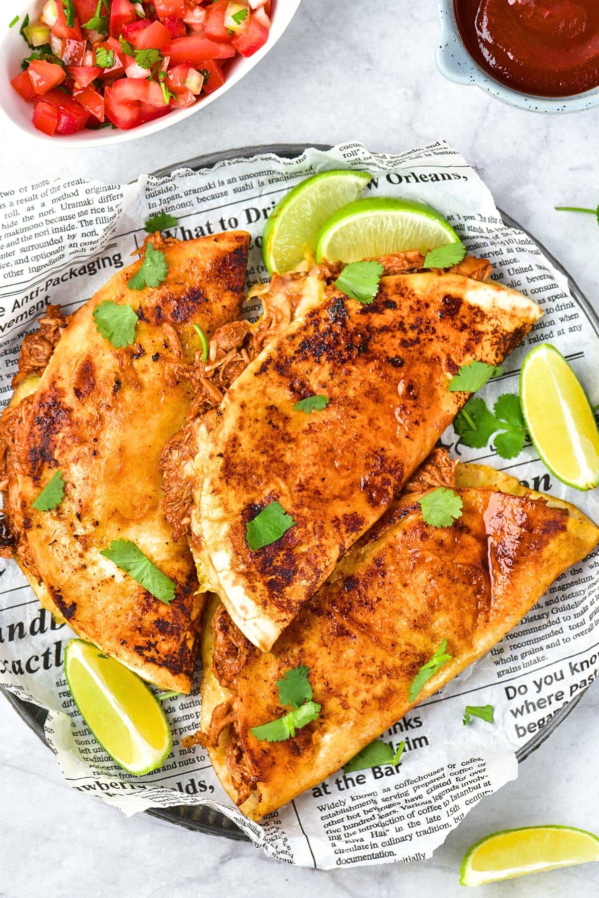 Top down view of chicken birria tacos on a parchment-lined plate.