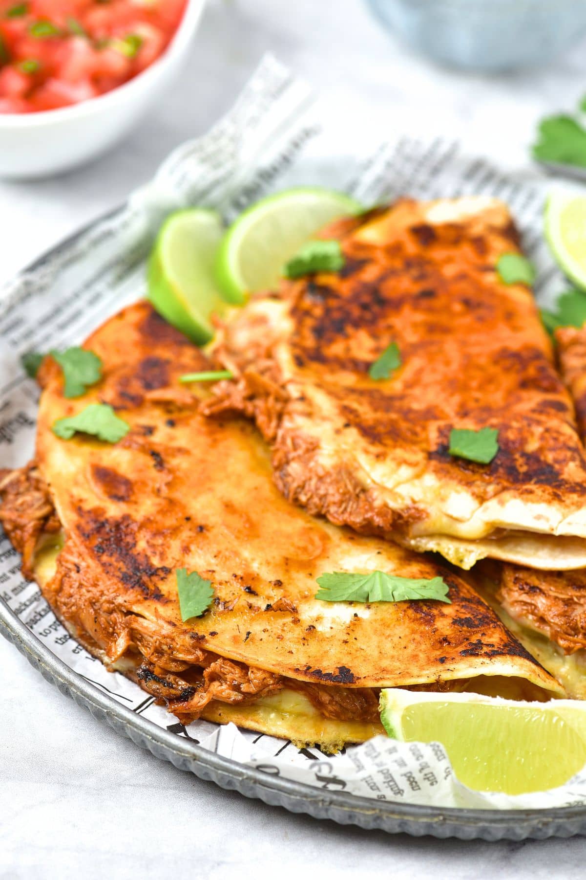 Up close of a chicken birria tacos on parchment-lined plate.