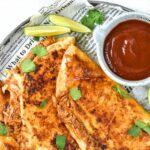 Tacos and birria sauce on plate