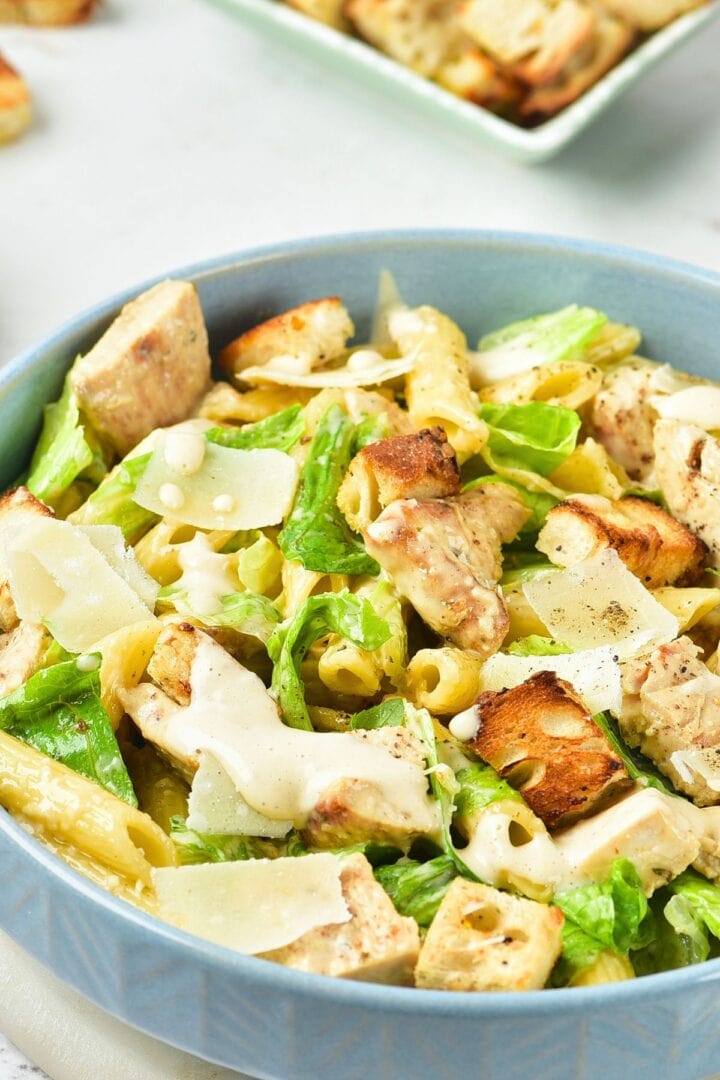 Up close view of a bowl of gluten-free chicken caesar pasta salad