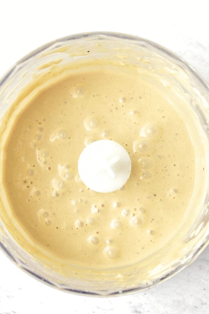 Creamy caesar salad dressing in food processor.