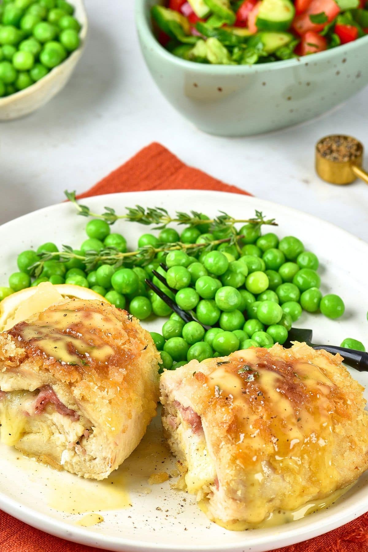 Gluten-Free Chicken Cordon Bleu Recipe A plate with sliced chicken cordon blue and green peas