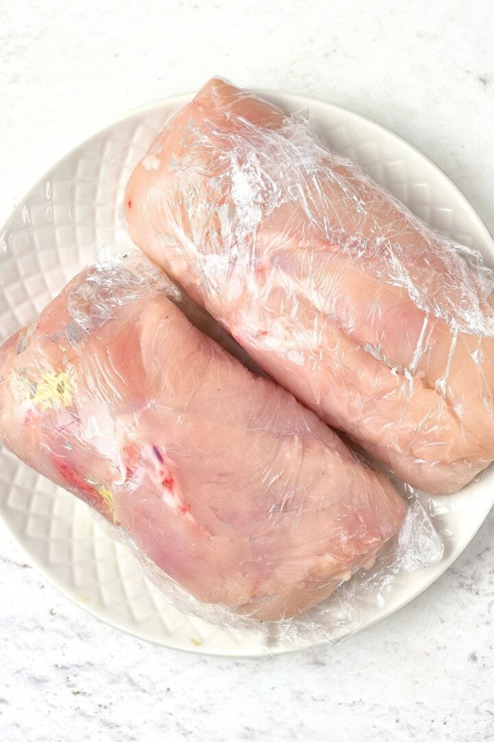 Rolled chicken fillets wrapped in plastic wrap