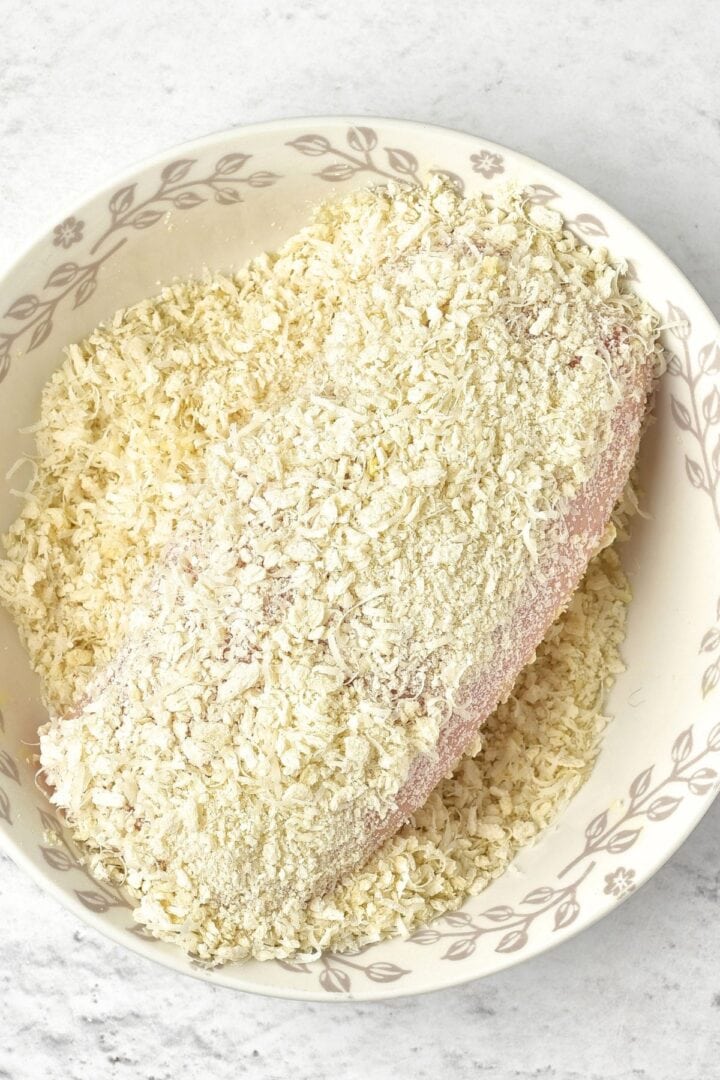 Coating chicken in a bowl of panko breading mixture
