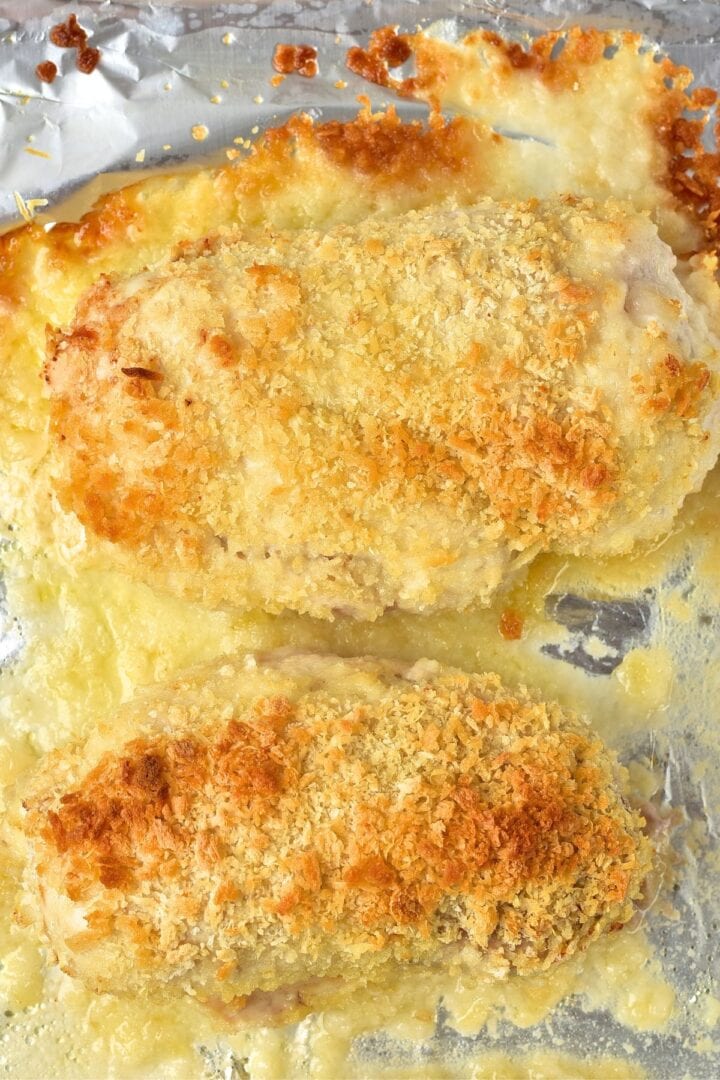 Golden brown baked chicken breasts on aluminum foil