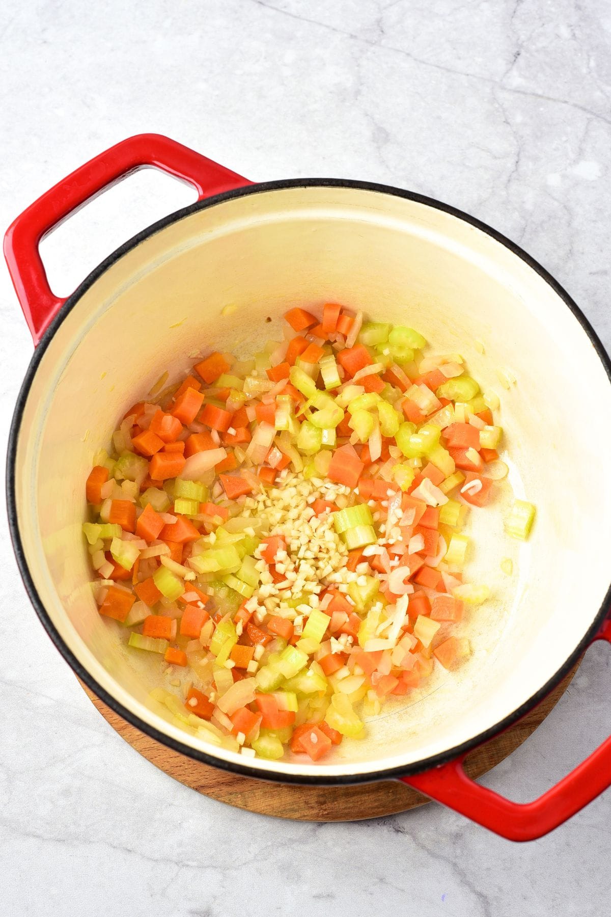 Sautéing cubed carrots, celery, onions and garlic in Dutch oven.