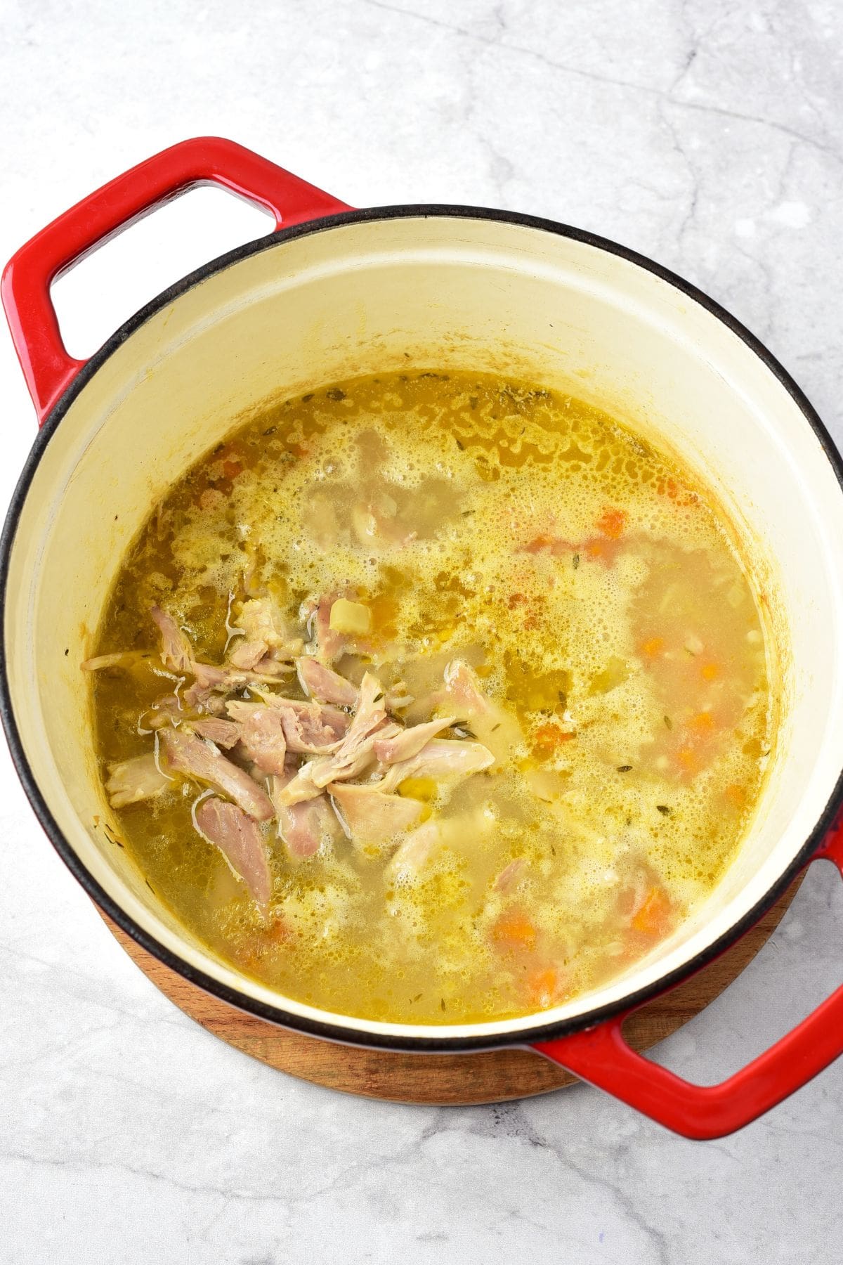 Shredded chicken in a pot of soup