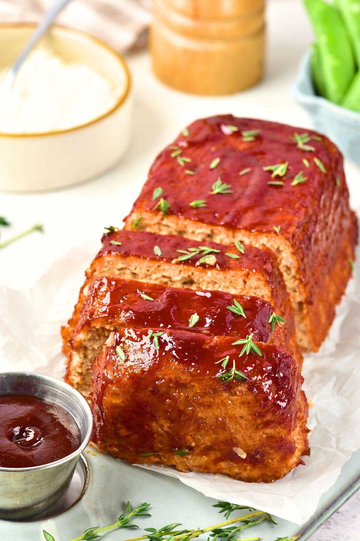 Ground chicken meatloaf topped with fresh thyme leaves