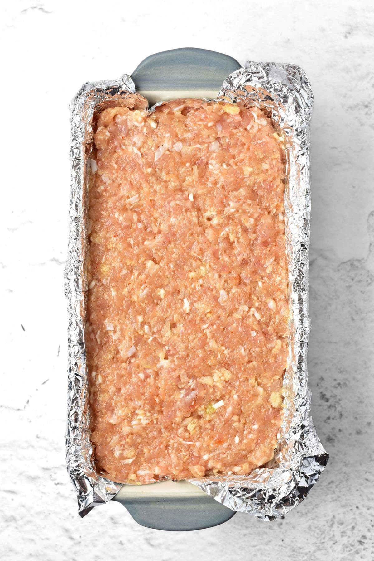 Ground chicken mixture in foil-lined loaf pan