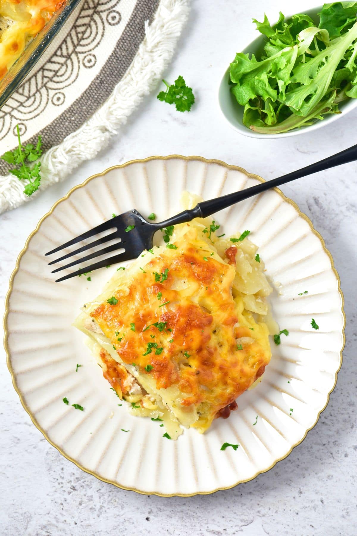 Top down view of a plate of baked chicken and potatoes