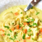 Up close view of a bowl of tortellini and chicken soup