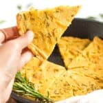 Holding up a wedge of chickpea flatbread.