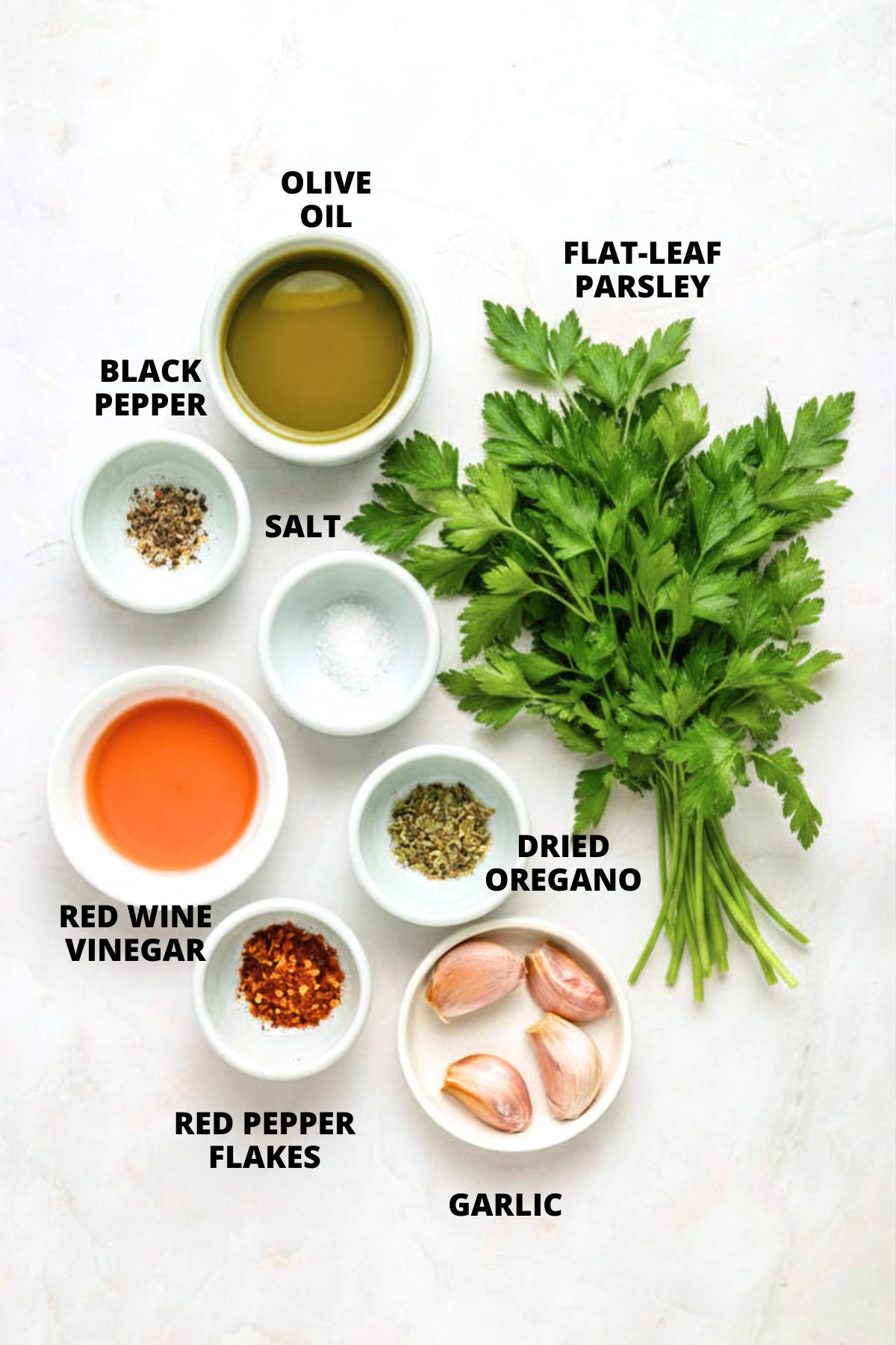 Ingredients for chimichurri steak recipe laid out on white board.
