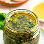 Up close view of a jar or basil chimichurri sauce.