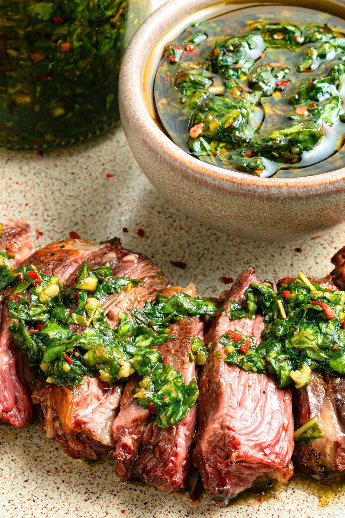 Grilled chimichurri steak with a bowl of chimichurri sauce