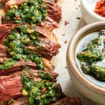Chimichurri steak and bowls of chimichurri sauce