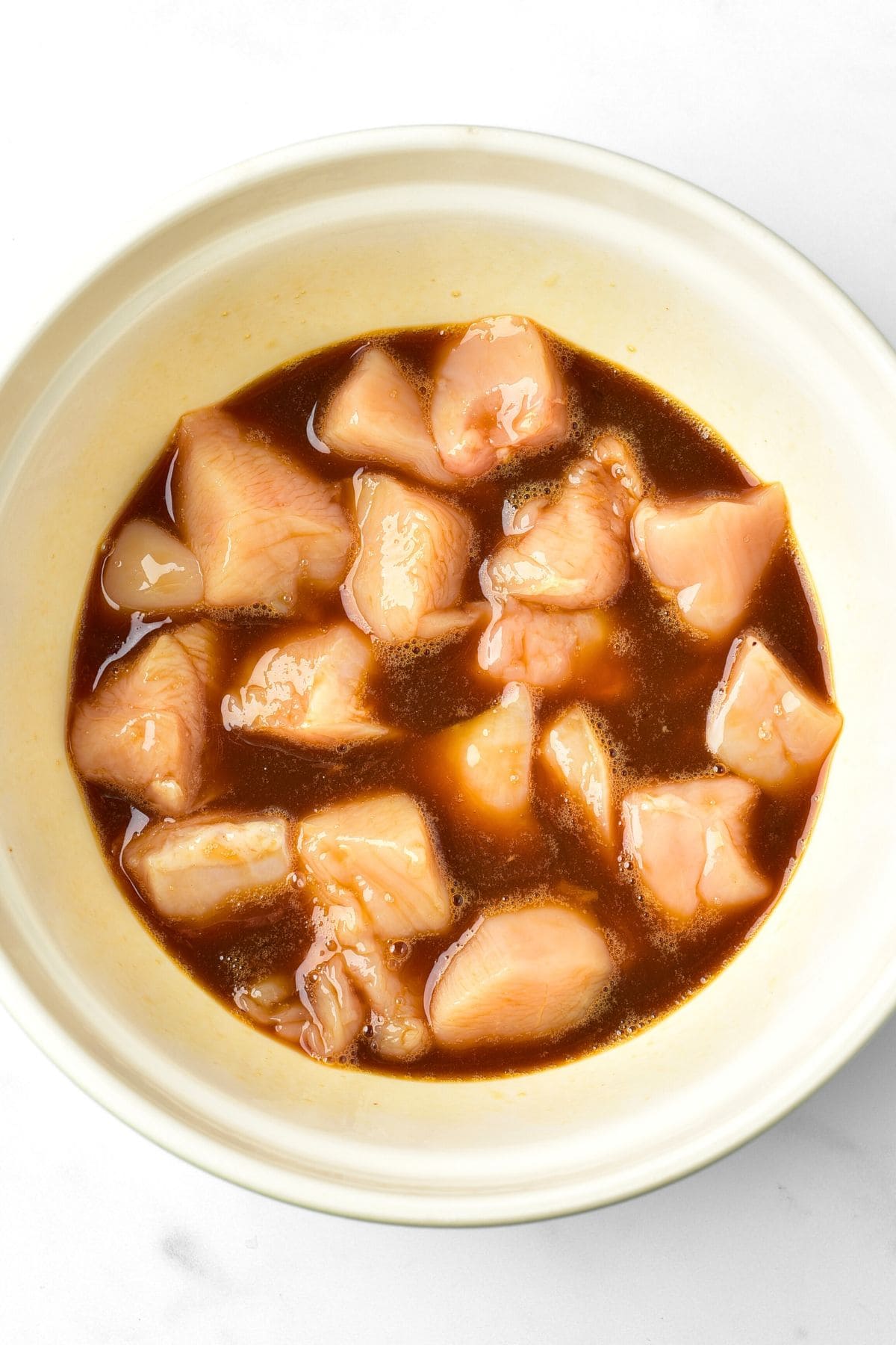 Chicken cubes marinating in a bowl