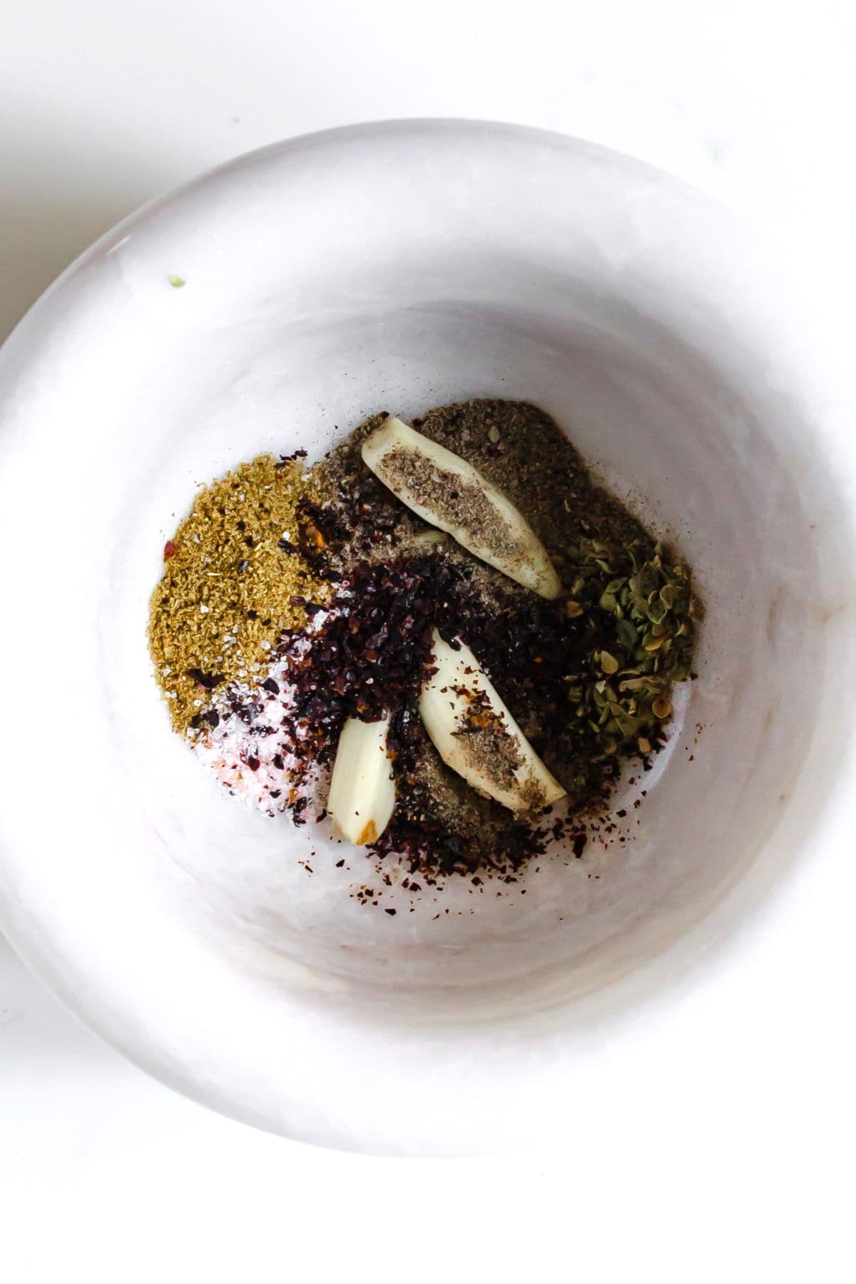 Chipotle Style Steak Bowl (Gluten-Free, Dairy-Free) Garlic cloves and dried condiments in mortar