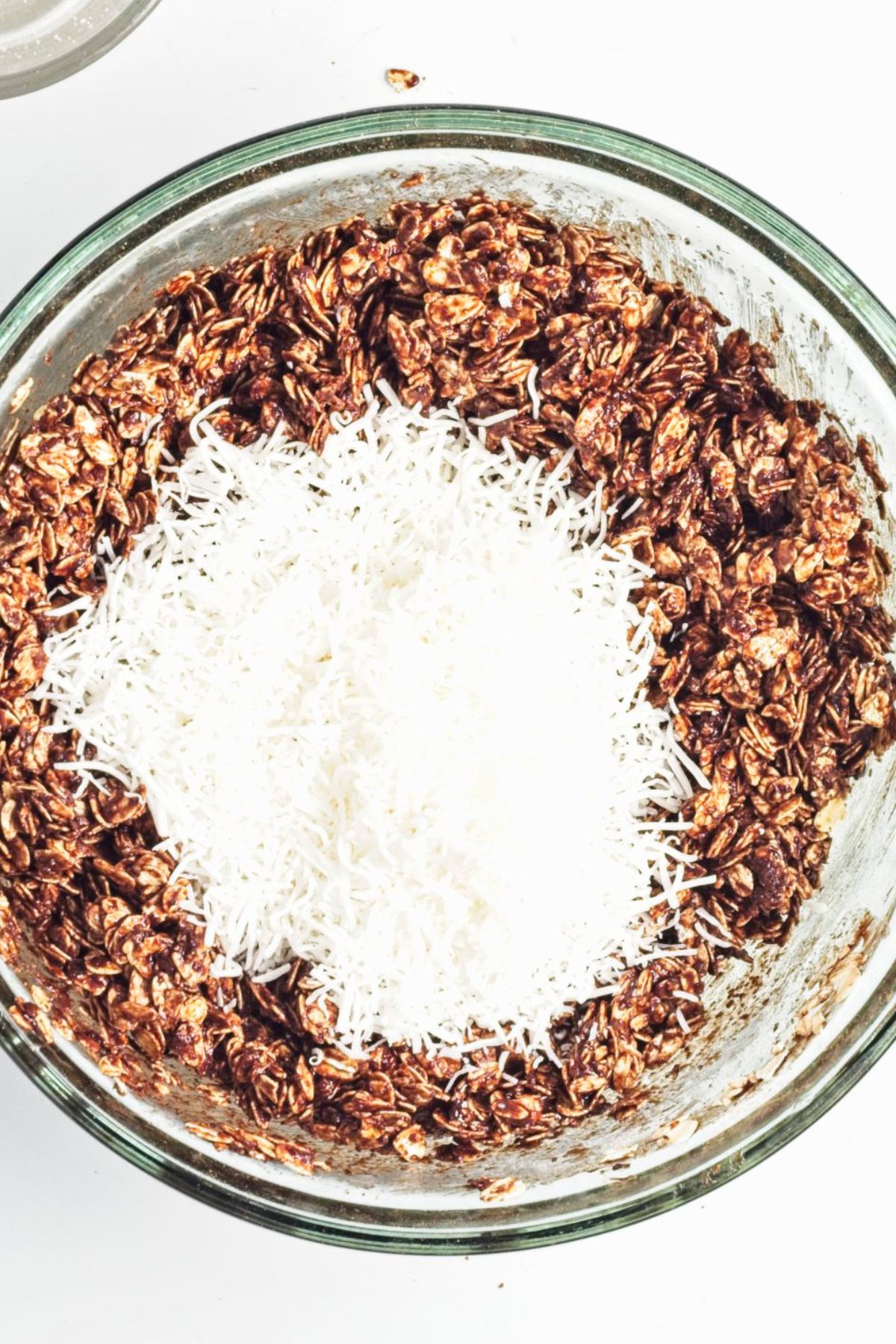 A bowl of chocolate granola topped with shredded coconut 