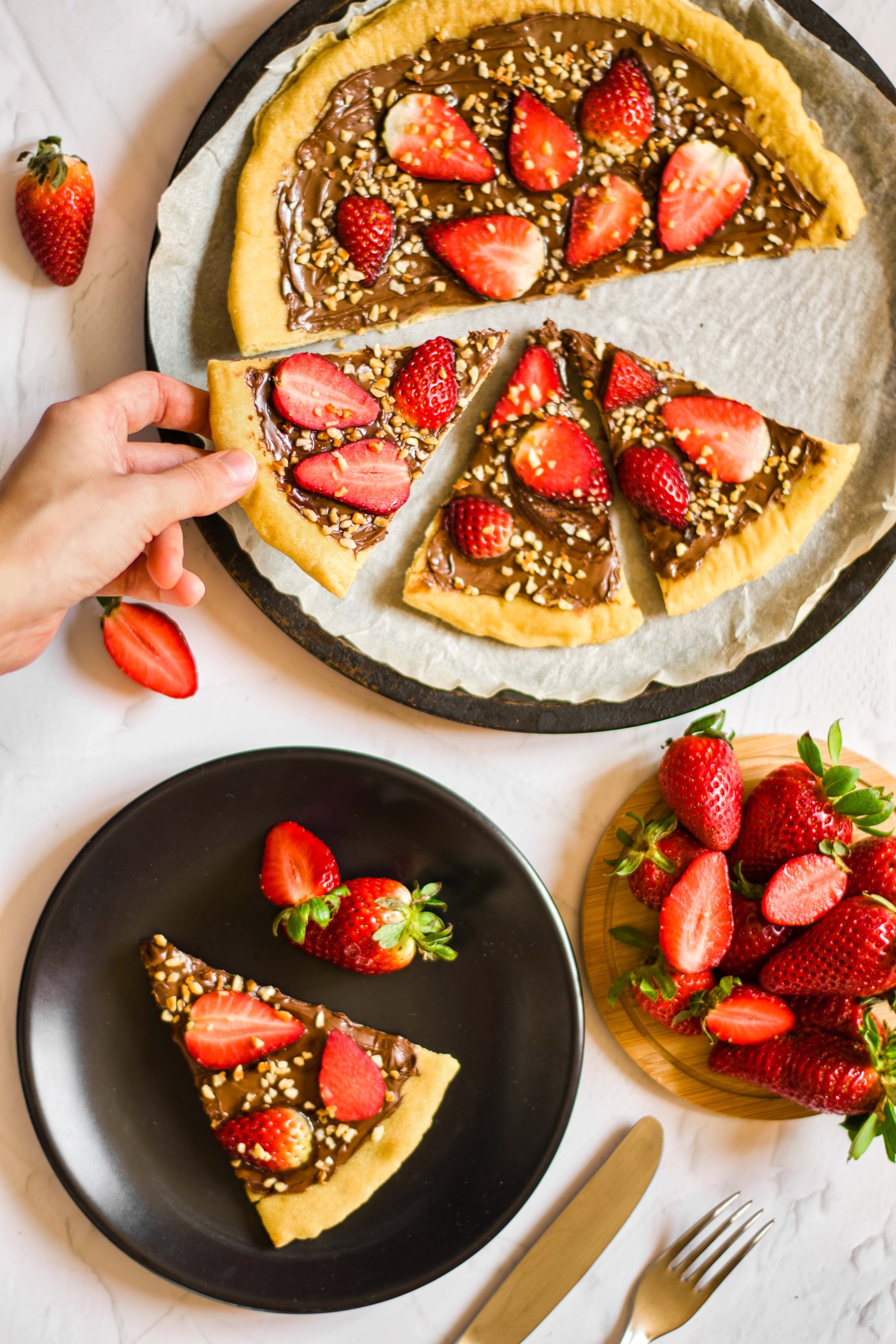 Hand reaching for a slice of gluten-free dessert pizza.