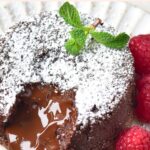 Half-eaten gluten-free lava cake with fresh raspberries