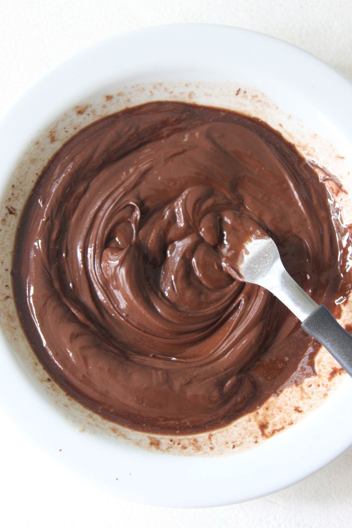 Mixing melted chocolate in bowl.
