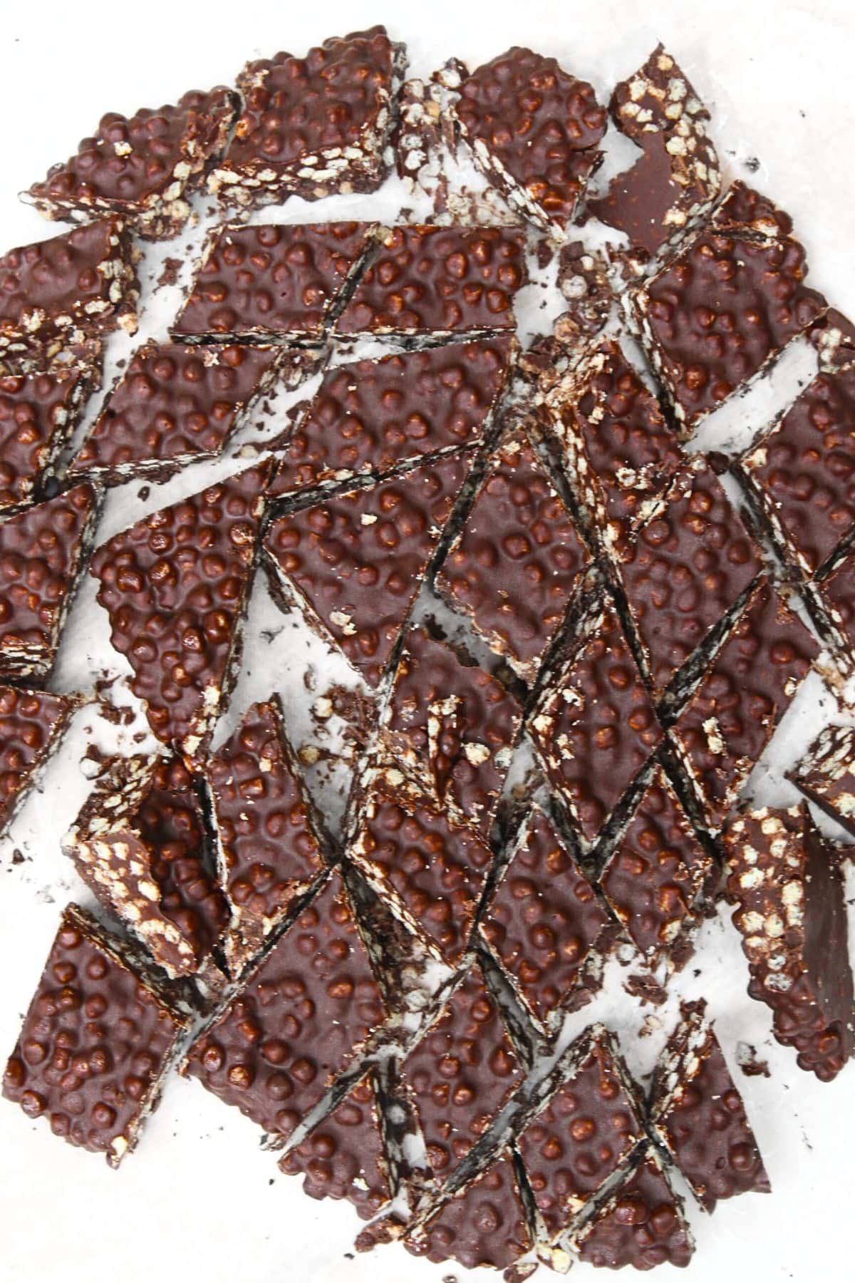 Pieces of quinoa chocolate crisps on parchment paper.