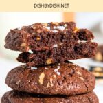 A stack of half-eaten chocolate cookies with walnuts