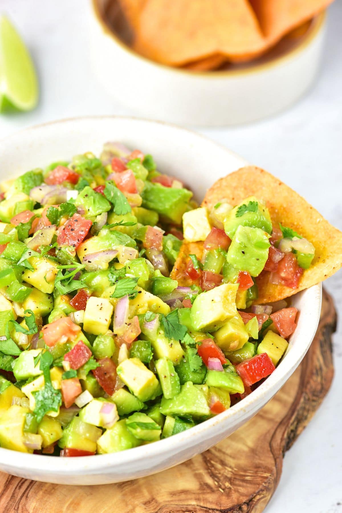 A bowl of chunky avocado salsa with tortilla chips