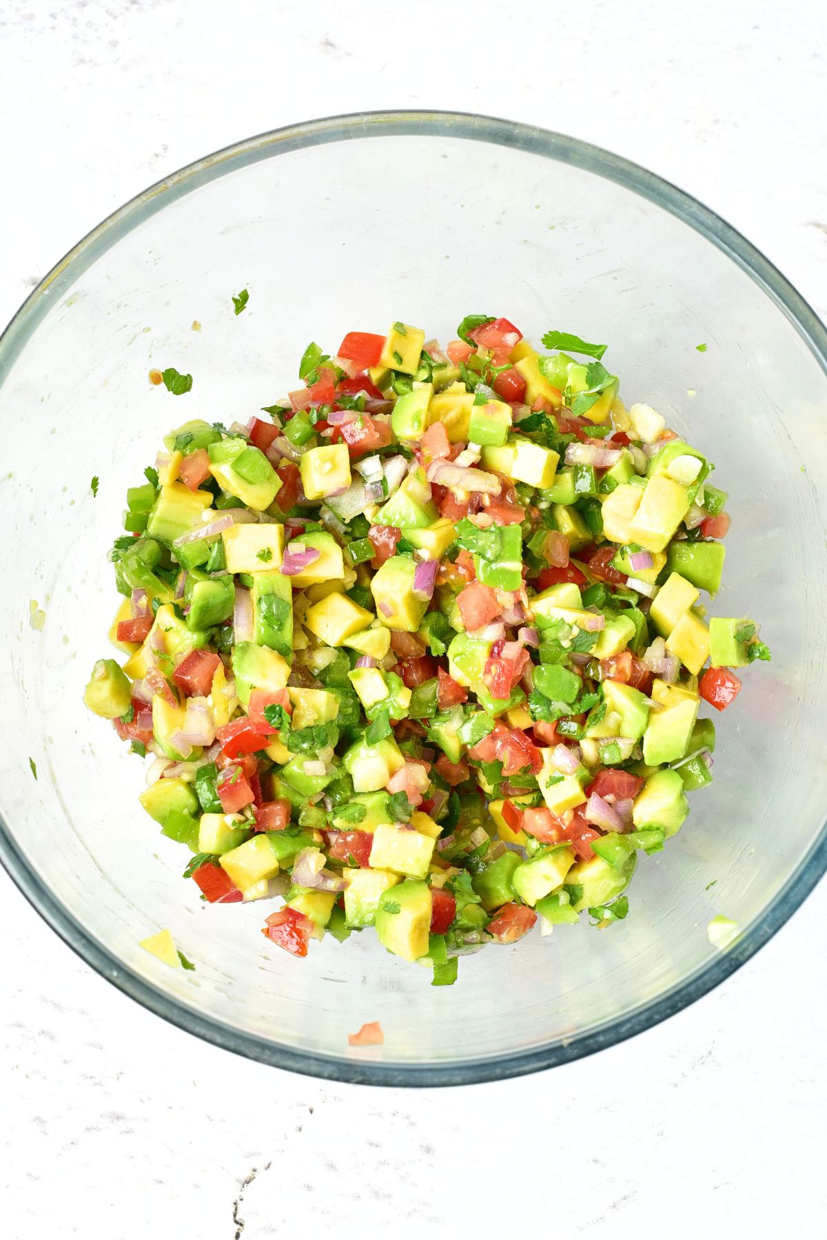 Avocado salsa tossed in glass bowl