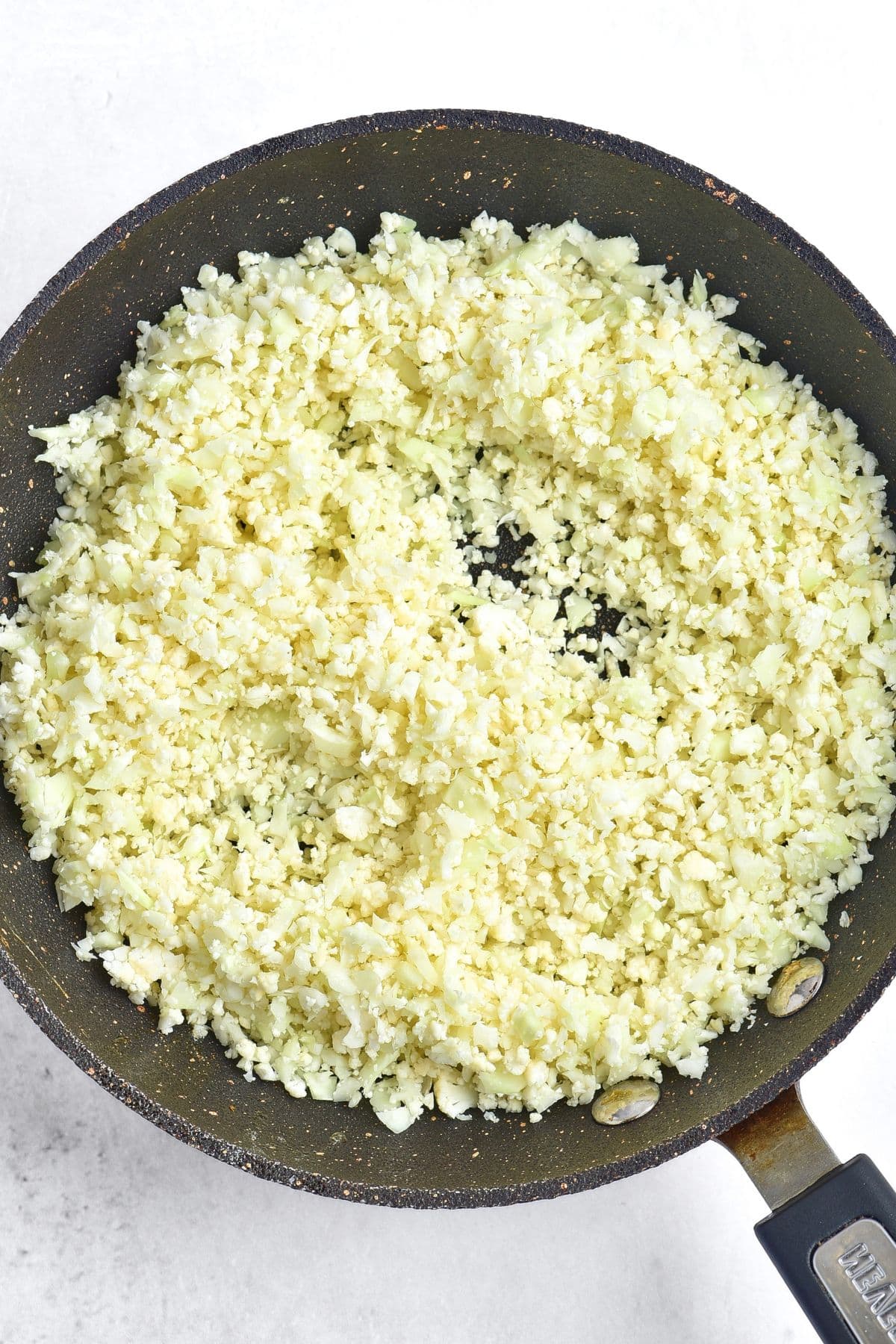 Sautéing cauliflower rice in skillet