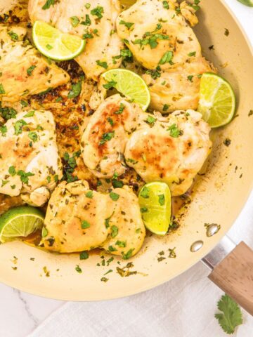 Top down view of cilantro lime chicken thighs in skillet