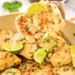 Holding up cilantro lime chicken thighs from skillet