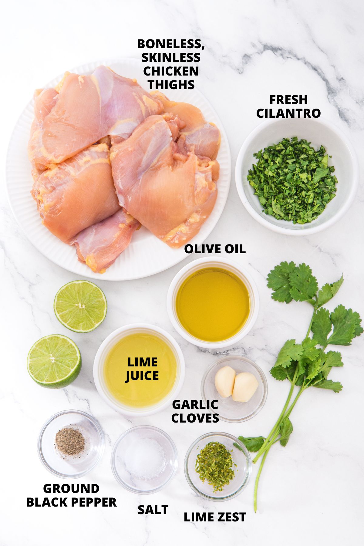 Ingredients for cilantro lime chicken thighs recipe laid out on marble board.