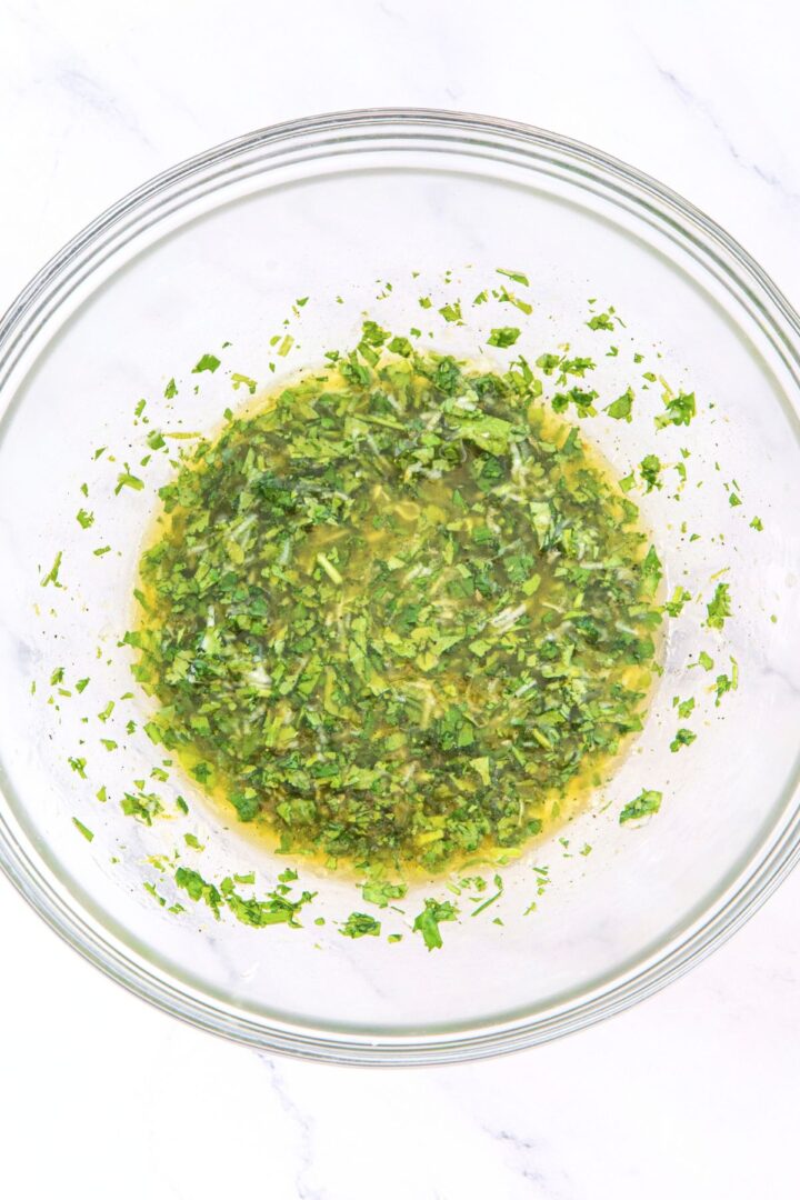 A bowl of chopped cilantro, lime juice, minced garlic