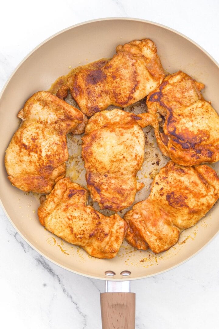 Seared chicken thighs in skillet