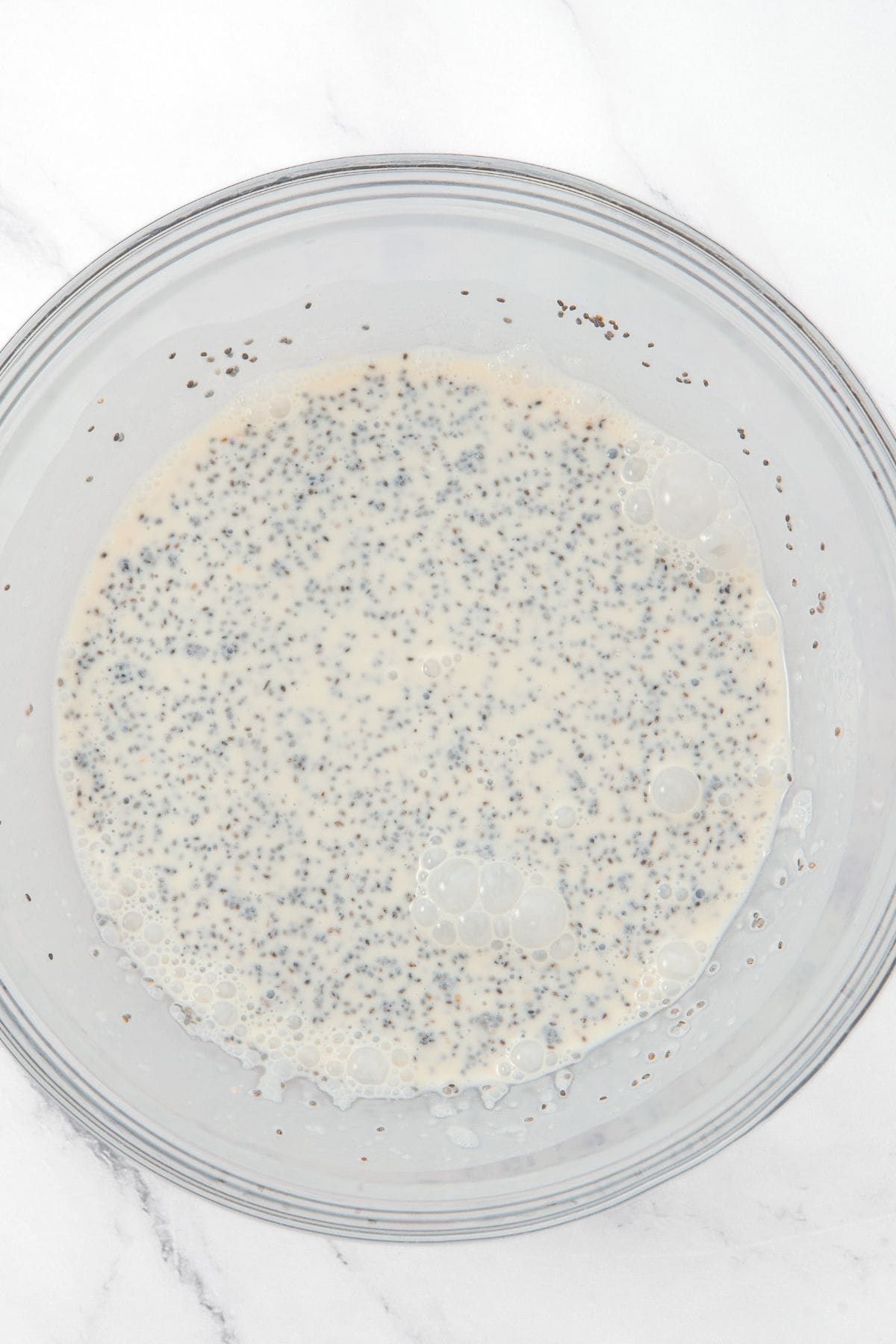 A mixture of milk and chia seeds in a bowl.