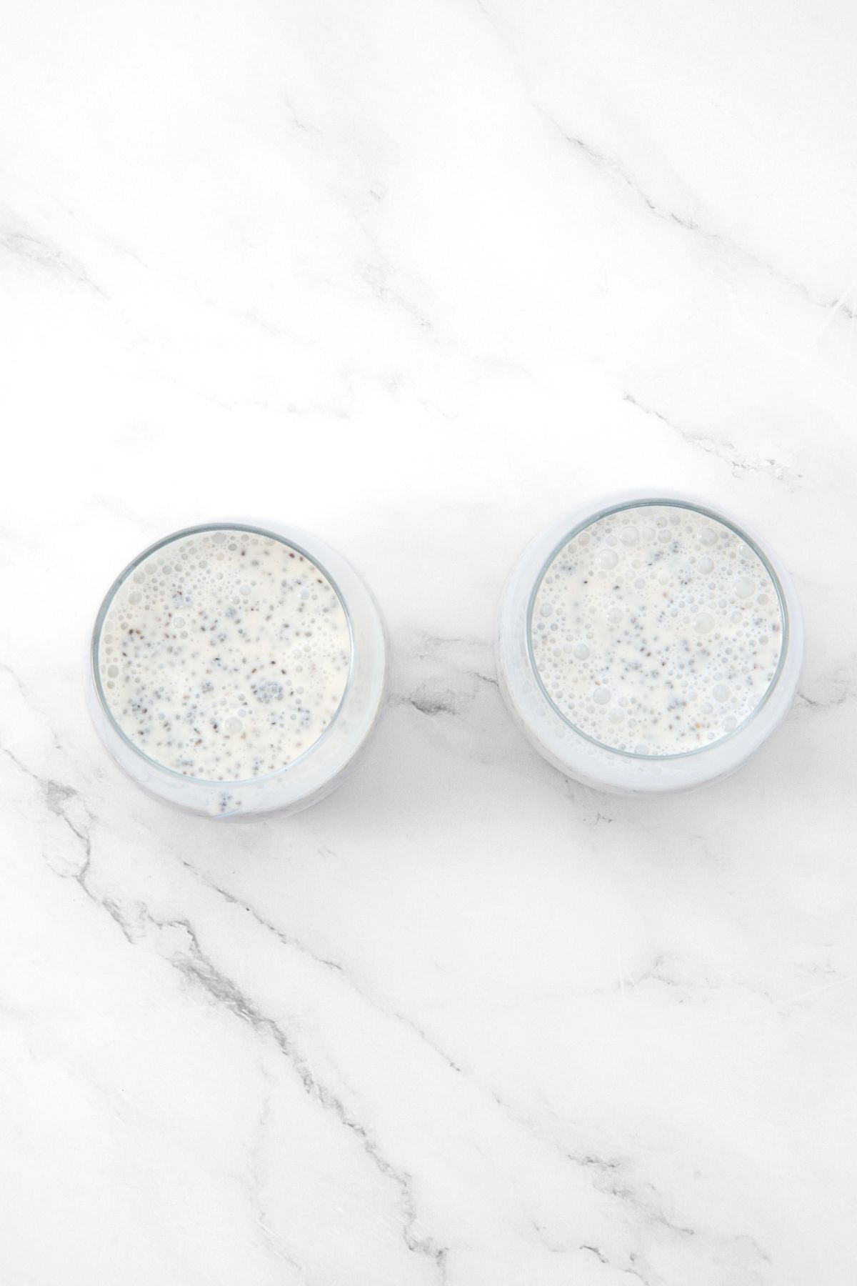 Glasses of chia pudding on marble board.
