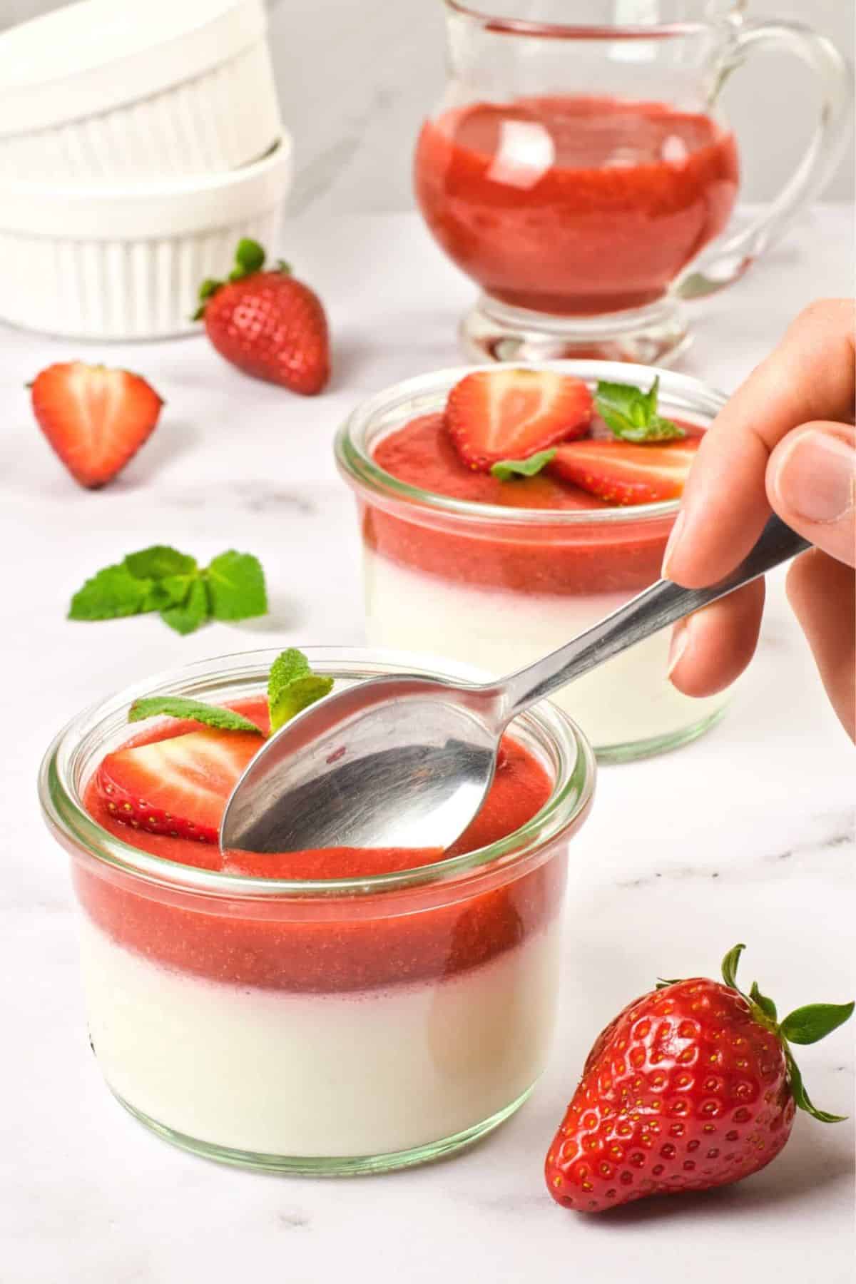Scooping into a bowl of strawberry-topped coconut milk panna cotta.