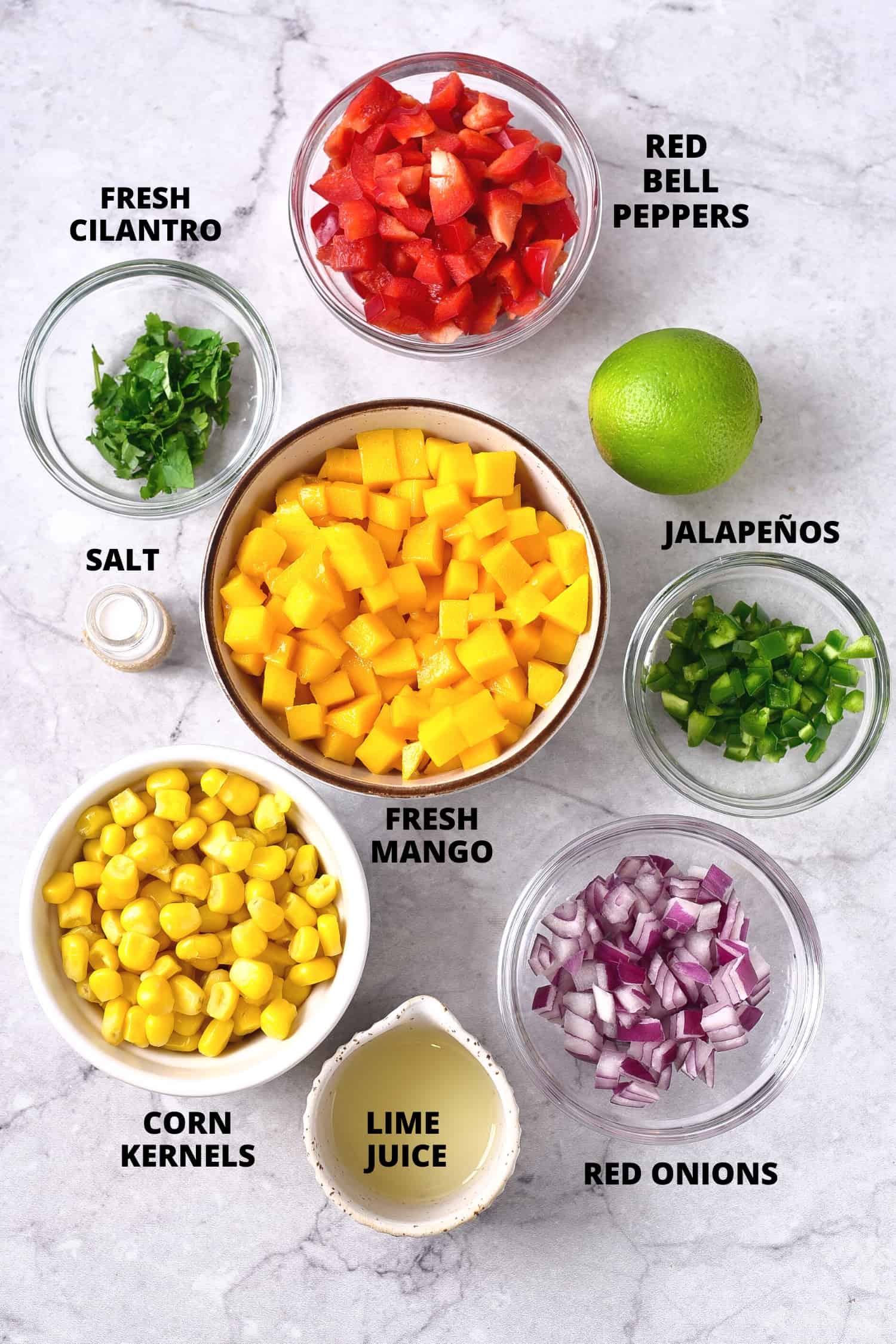 Ingredients required for corn mango salsa recipe laid out on board.