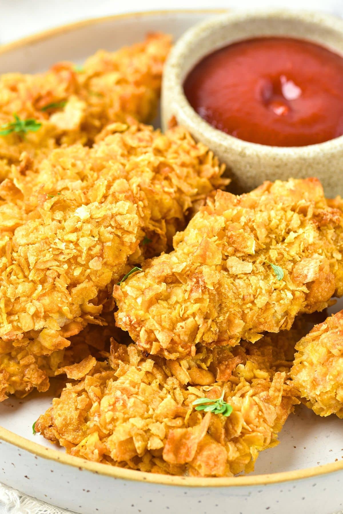 A plate full of crispy cornflake chicken strips