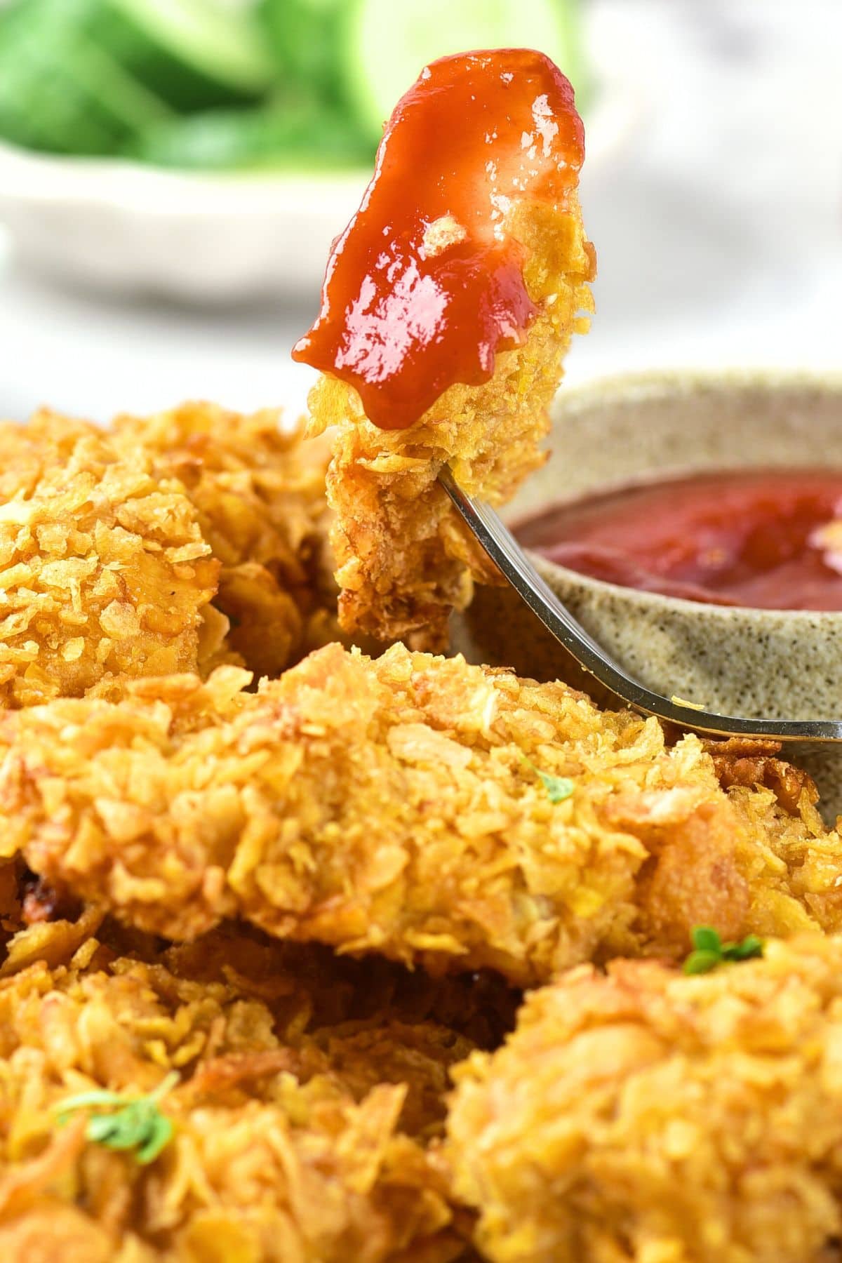 Holding up half-eaten piece of gluten-free cornflake chicken