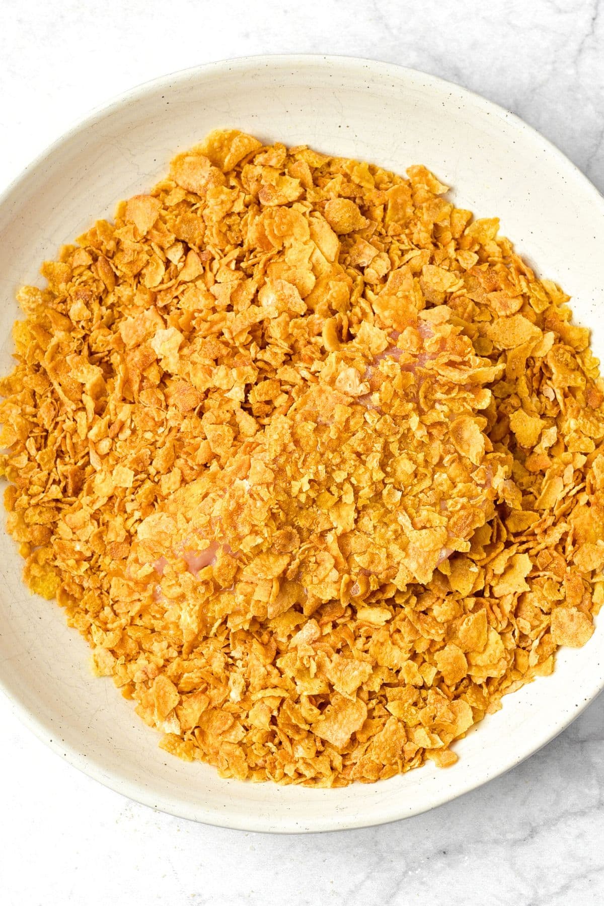 Coating chicken in crushed cornflakes