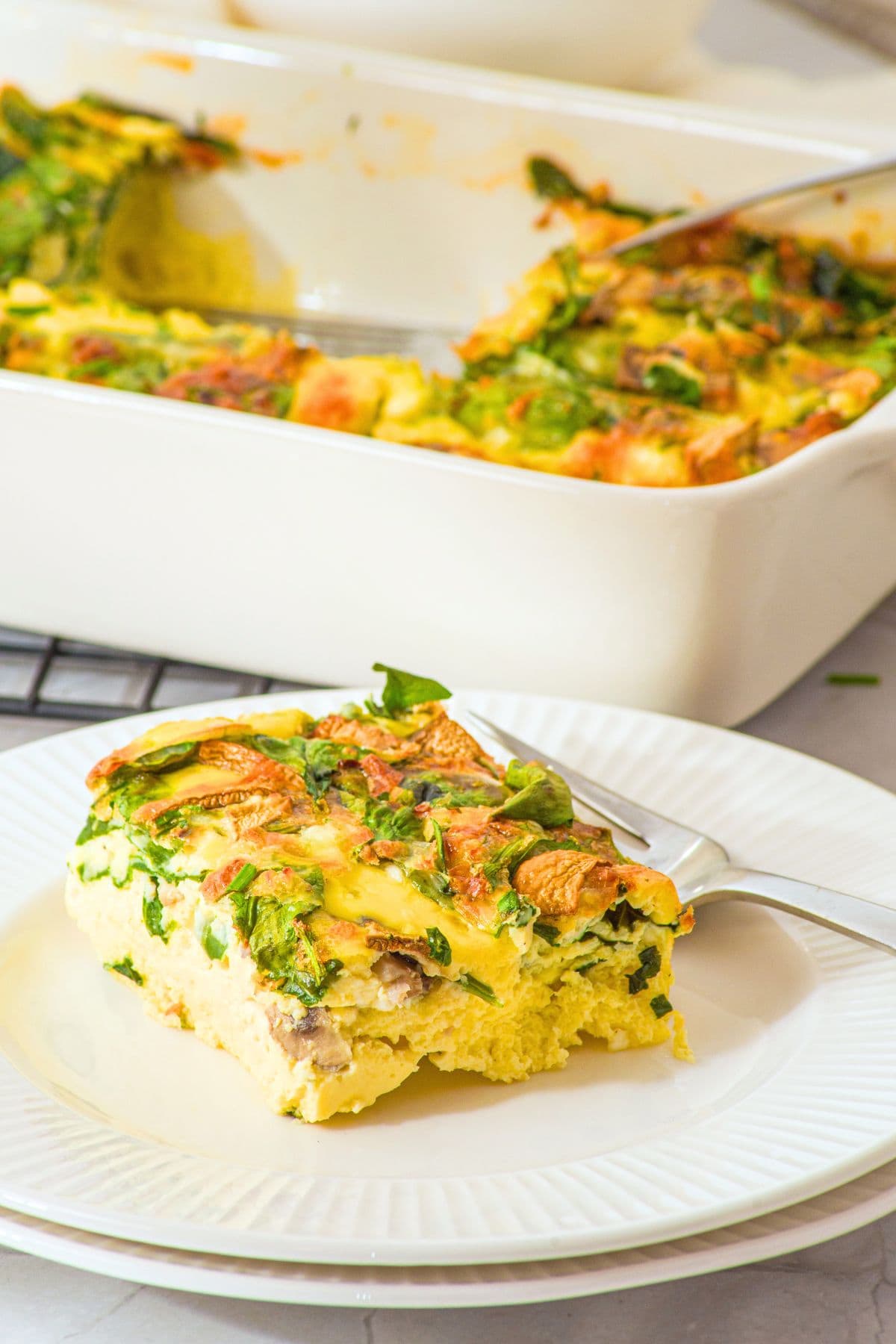 A slice of cottage cheese baked eggs on white plate.