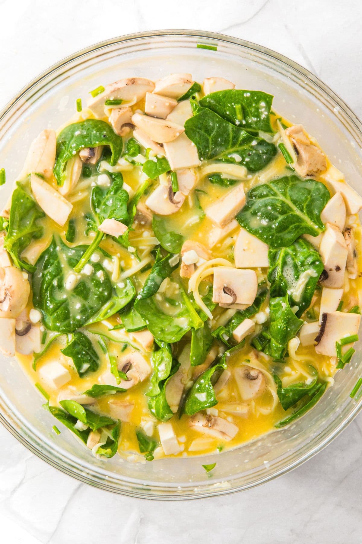 A mixture of beaten eggs, cottage cheese, mushrooms and spinach