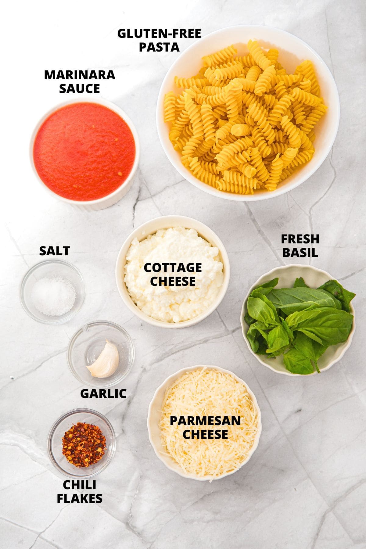 Ingredients for cottage cheese pasta sauce recipe laid out on white board.
