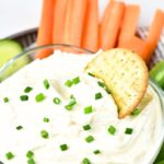 A bowl of cottage cheese ranch dip sprinkled with chopped chives.